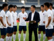 足球比赛中场休息时教练与球员战术讨论的场景